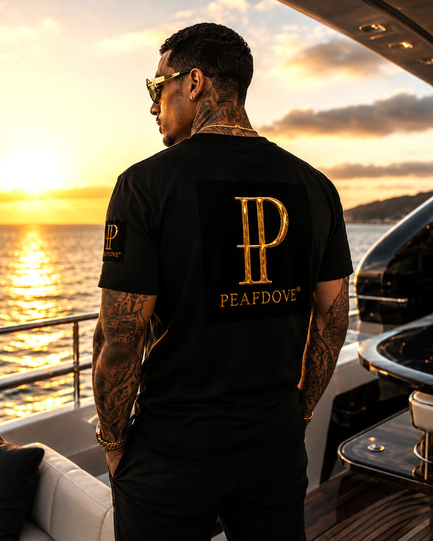 PEAFDOVE® GOLD MONOGRAM — Billionaire Signature Shirt Quiet luxury. Visible authority. The PEAFDOVE® Gold Monogram Shirt carries the gilded PEAFDOVE signature as a controlled statement across the chest. No loud graphic. No overloaded design. Just one unmistakable symbol for men who never need to explain.